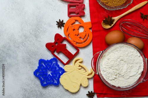 collection or set of bakeware for the holidays christmas, mothers day, halloween, plastic cookie cutters at home in the shape of a snowflake, cow or bull, and pumpkin, gift box