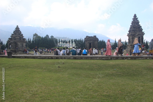 This photo is a photo of a tourist on vacation at the Dieng Temple complex. the location of the Dieng Plateau, Central Java, Indonesia.
