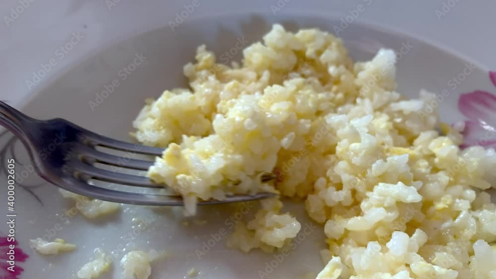 Elderly person with hand tremor because Parkinson disease eating cereal using folk close up Elderly person with hand tremor because Parkinson disease eating cereal using folk close up