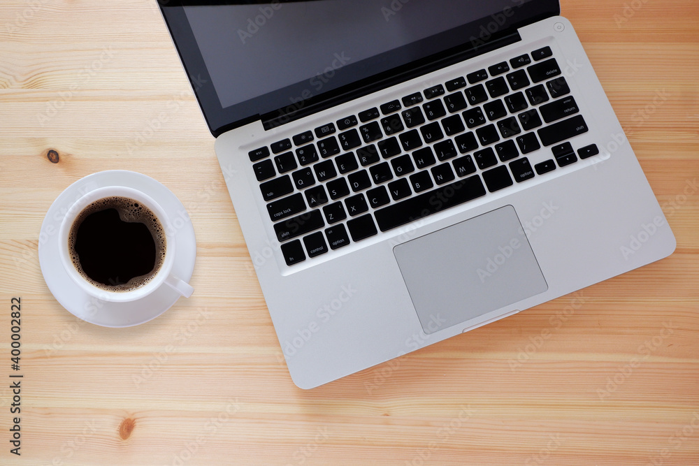 Laptop computer and black coffee in white cup on wooden desk with copy space, Top view. Laptop computer and black coffee in white cup on wooden desk with copy space, Top view.