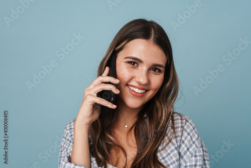 Joyful beautiful girl smiling while talking on mobile phone