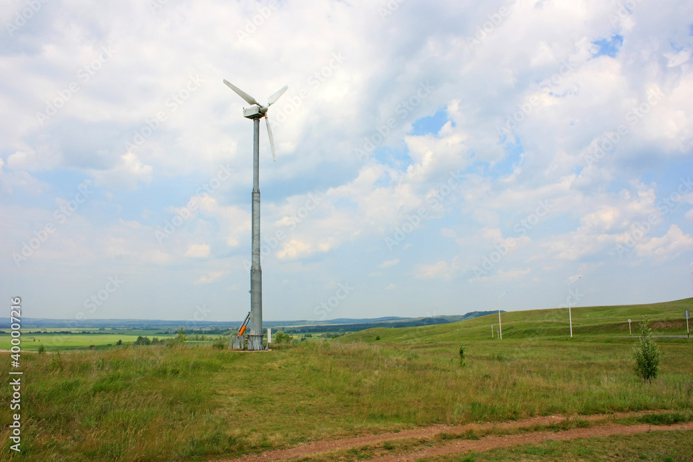 Fototapeta premium Wind turbine to generate electricity in a green field