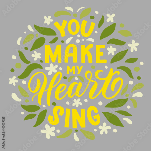 Vector image with inscription - you make my heart sing - yellow letters and leaves on a grey background. For the design of postcards, posters, banners, notebook covers, prints for t-shirt, pillows © Irina
