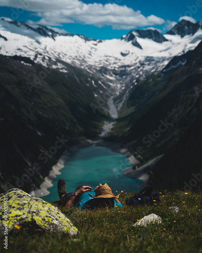 Schlafender Mann mit Strohhut in den Bergen mit Blick auf blauen See