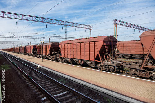 grain carrier freight car for transportation of bulk cargo of grain crops, railway track with rails and wagons going into perspective, background on theme of transportation and export of grain nobody. photo