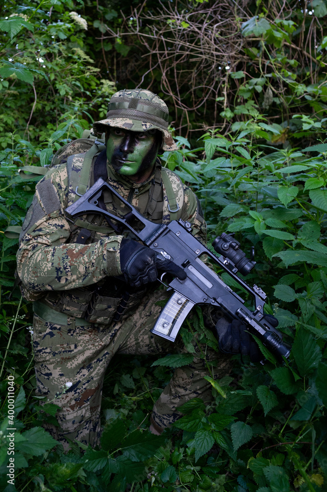 Croatia recon forces soldier camouflaging in the forest with the 
Cropat woodland uniform and assault rifle.