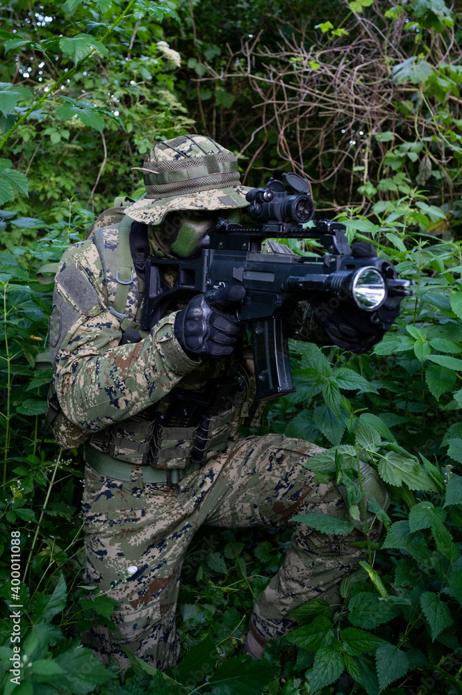Croatia recon forces soldier camouflaging in the forest with the 
Cropat woodland uniform and assault rifle.