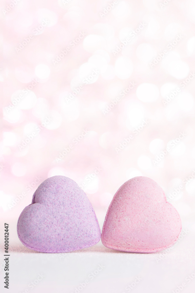 Obraz premium Vertical Valentines day greeting card , 2 pastel pink hearts on gentle pink background with bokeh and place for text