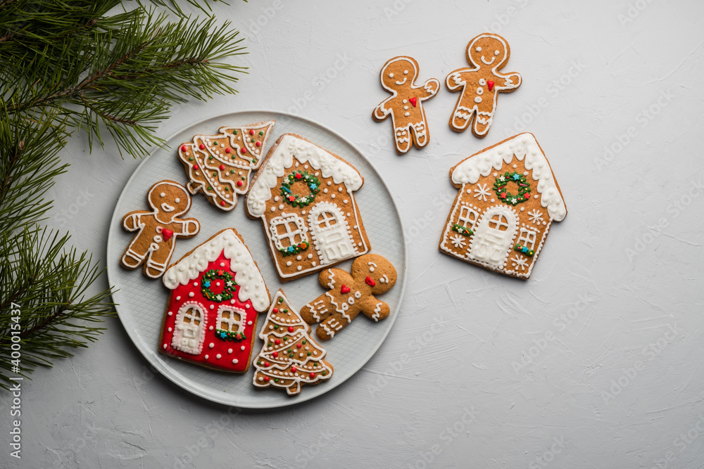 New Year's round dance of gingerbread men and gingerbread trees and houses on a gray background with copy space.
