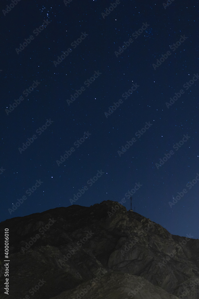blue starry night sky with rocky mountains background in Lima Peru