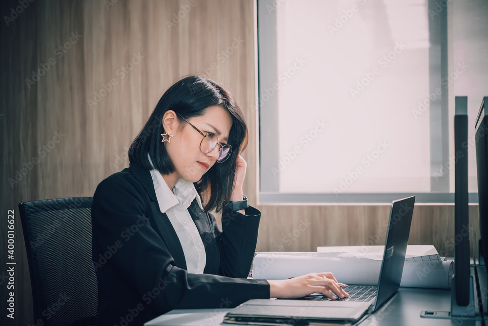 Asian woman working in office,young business woman stressed from work overload with a lot file on the desk,Thailand people thinking something Asian woman working in office,young business woman stressed from work overload with a lot file on the desk,Thailand people thinking something