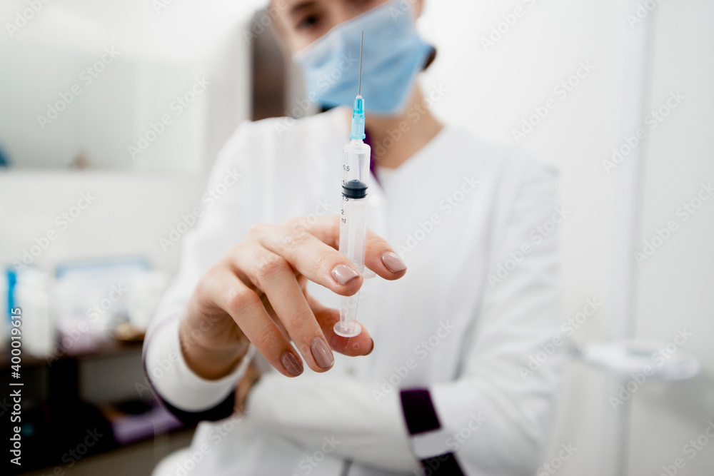 Young white doctor with syringe is ready to make injection Young white doctor with syringe is ready to make injection