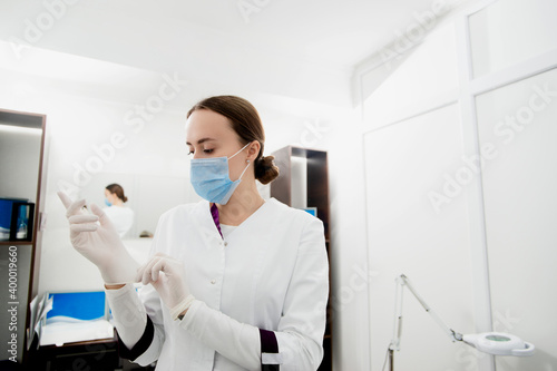 Young white cosmetologist is preparing to checkup her patients