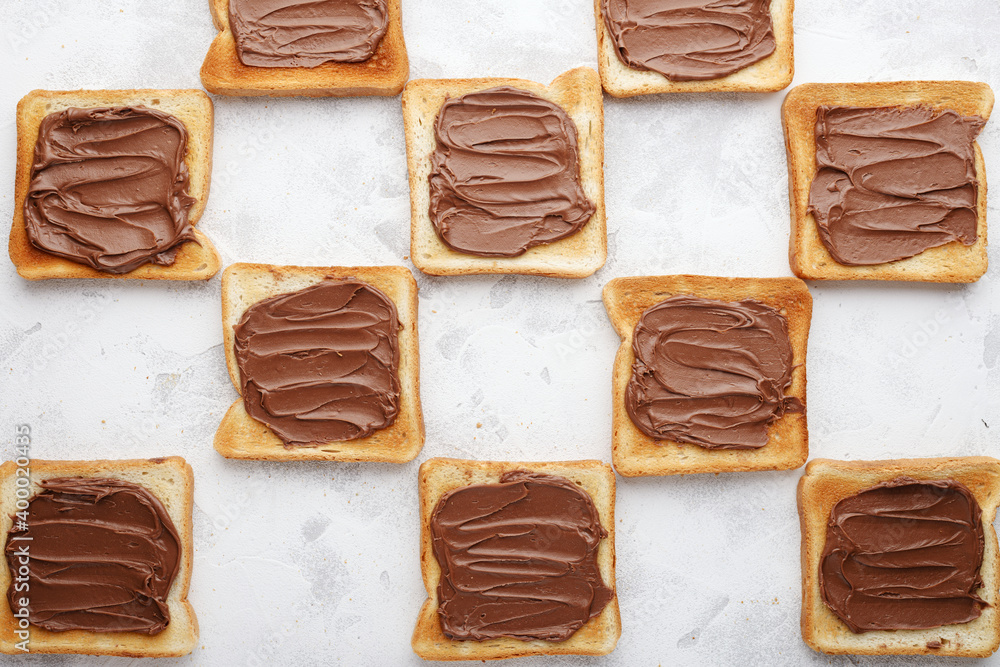 Toasted bread with chocolate-nut paste spread decomposition staggered top view Toasted bread with chocolate-nut paste spread decomposition staggered top view
