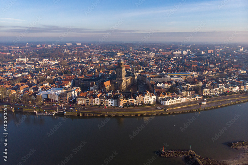 Aerial cityscape panorama of the Dutch medieval city of Deventer in The Netherlands seen from the other side of the river IJssel that passes it at sunrise