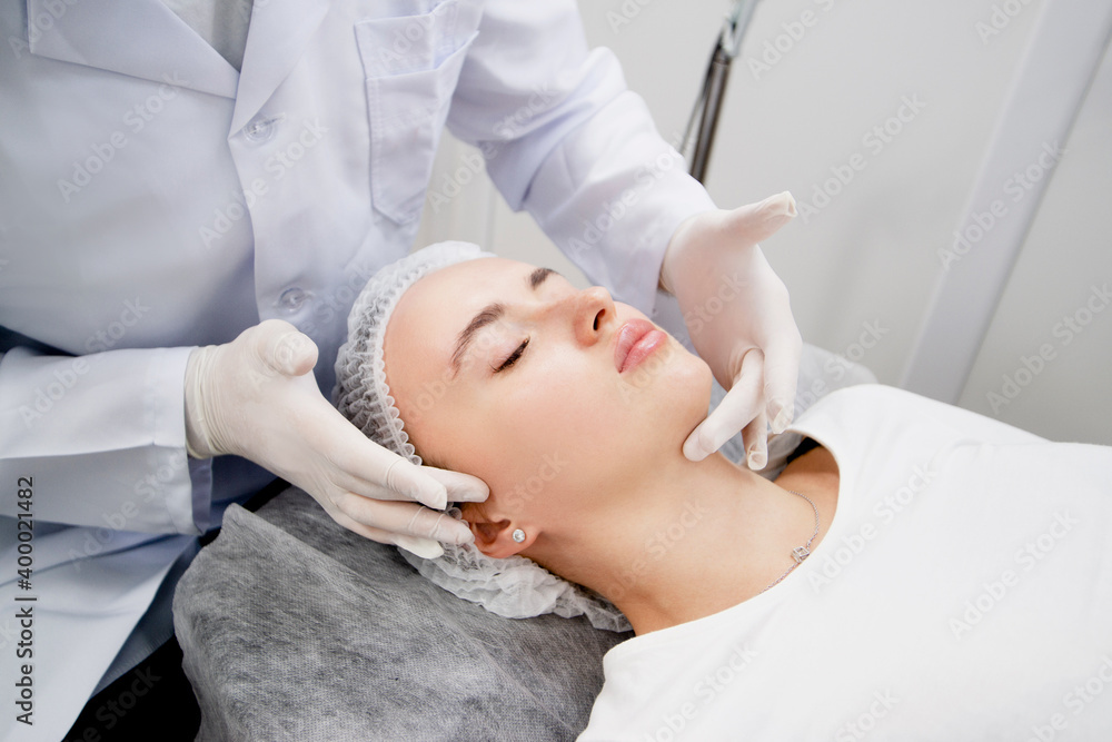 Young woman is getting prepared her skin by massage to make it ready and relaxed for procedure at the beauty salon Young woman is getting prepared her skin by massage to make it ready and relaxed for procedure at the beauty salon