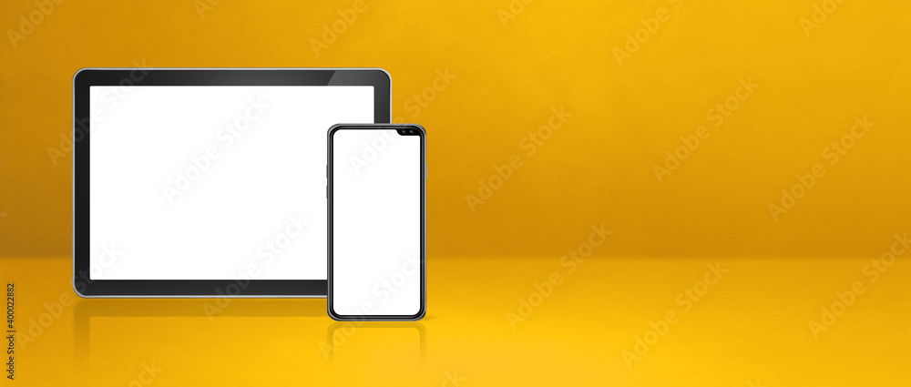 Mobile phone and digital tablet pc on yellow office desk. Background banner Mobile phone and digital tablet pc on yellow office desk. Background banner
