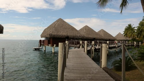 Lovey tahitian tourist cottages on the sea with wooden bridge to them. photo