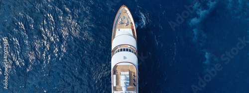 Aerial drone ultra wide photo of luxury yacht with wooden deck anchored in Mediterranean deep blue sea, Greece