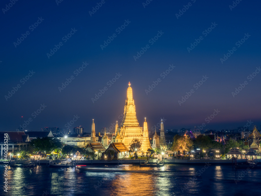 View of Wat Arun and Chao Phraya river at blue hours. Buddhist Temple and Landmarks in Bangkok Thailand