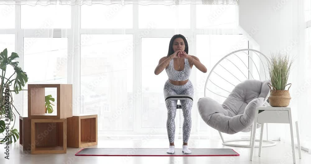Athletic black woman engaged in sports performs stretching exercises with elastic bands, working out home training. Healthy lifestyle. Fitness. Athletic black woman engaged in sports performs stretching exercises with elastic bands, working out home training. Healthy lifestyle. Fitness.