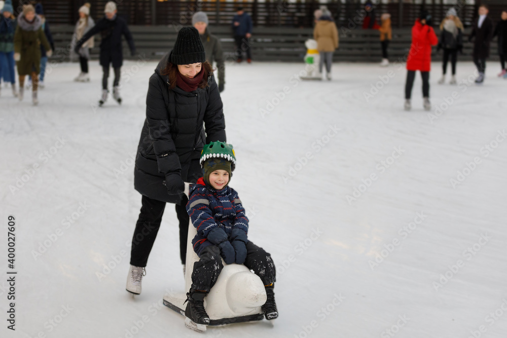 Mom and son skate on the ice rink Mom and son skate on the ice rink