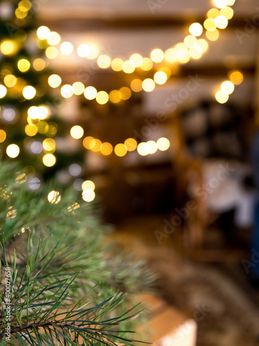 branch of a Christmas tree on the background of a beautiful yellow bokeh from garlands. Background