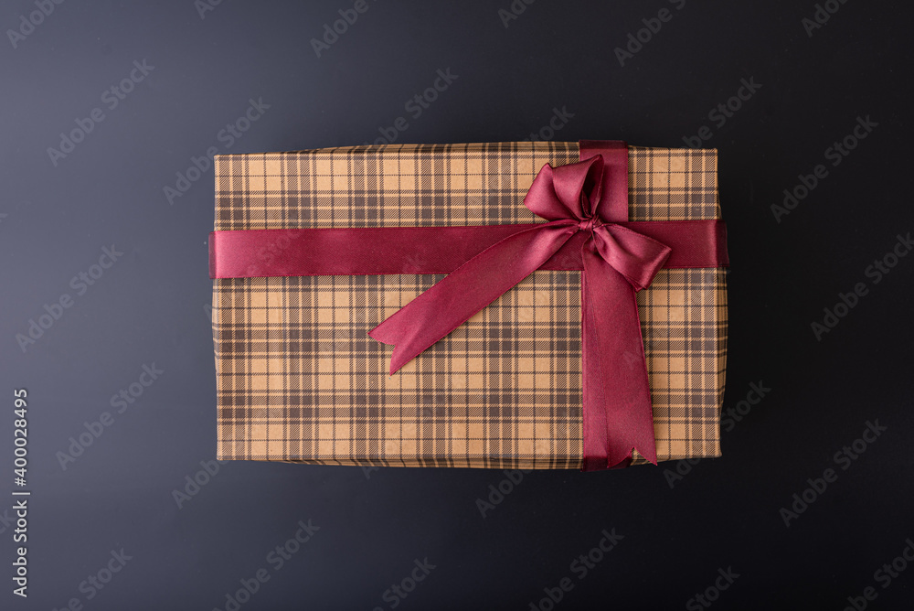 gift box with maroon ribbon on black background flat lay top shot gift box with maroon ribbon on black background flat lay top shot