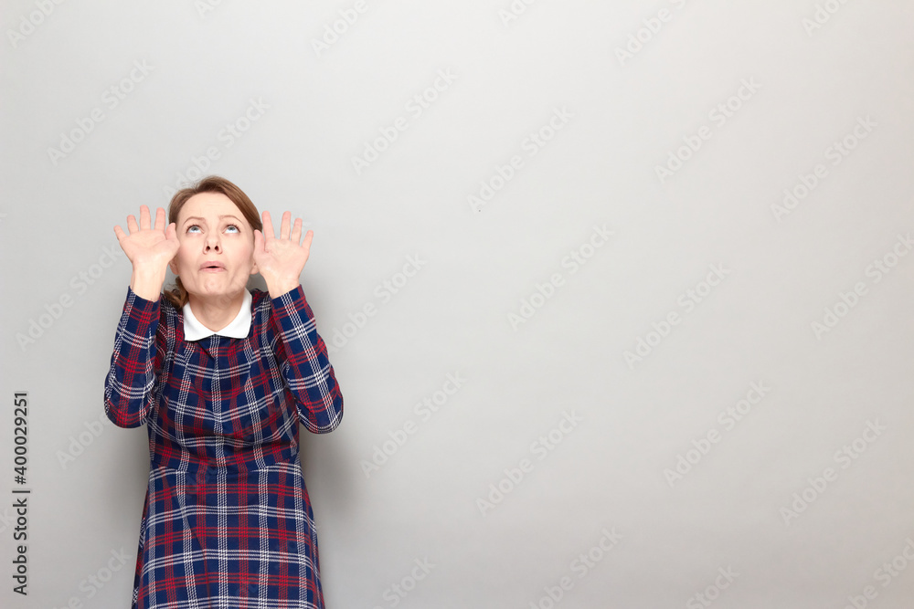 Portrait of frightened woman raising hands up to protect herself Portrait of frightened woman raising hands up to protect herself