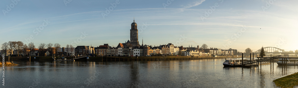 Cityscape panorama of the Dutch Hanseatic medieval city of Deventer in The Netherlands seen from the other side of the river IJssel at sunrise