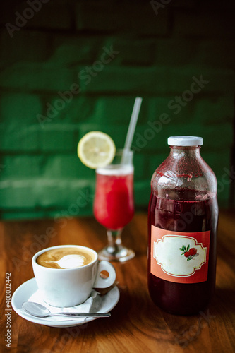 Close-up of cappuccino coffee and strawberry juice on the table in a cafe. Portrait format