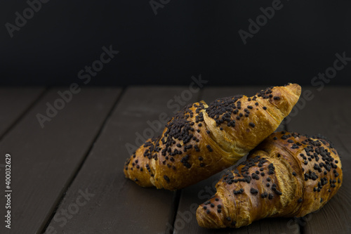 tasty croissants with chocolate on wooden background