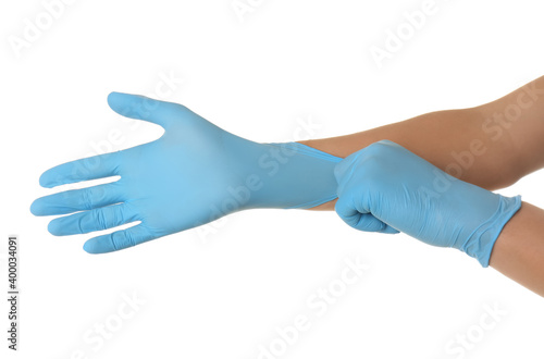 Person putting on blue latex gloves against white background, closeup © New Africa