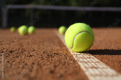 Bright yellow tennis ball on clay court