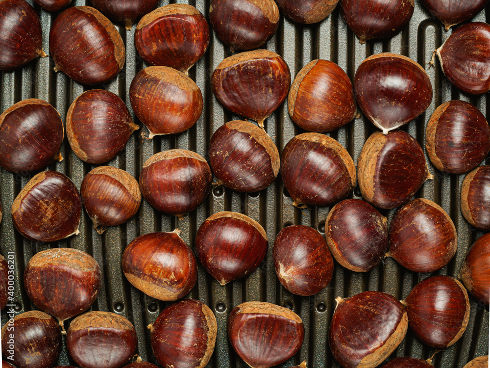 Fototapeta premium fresh chestnuts are laid out on the grill, roasting chestnuts