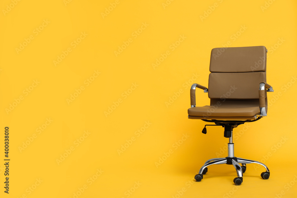 Modern office chair on yellow background. Space for text Modern office chair on yellow background. Space for text