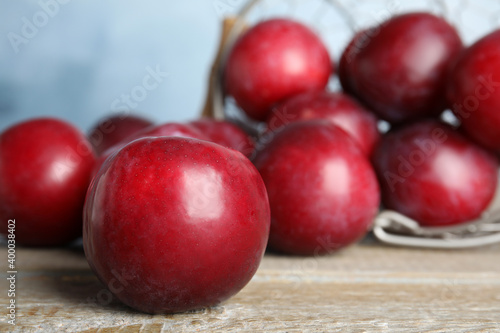 Delicious ripe plums on wooden table, closeup