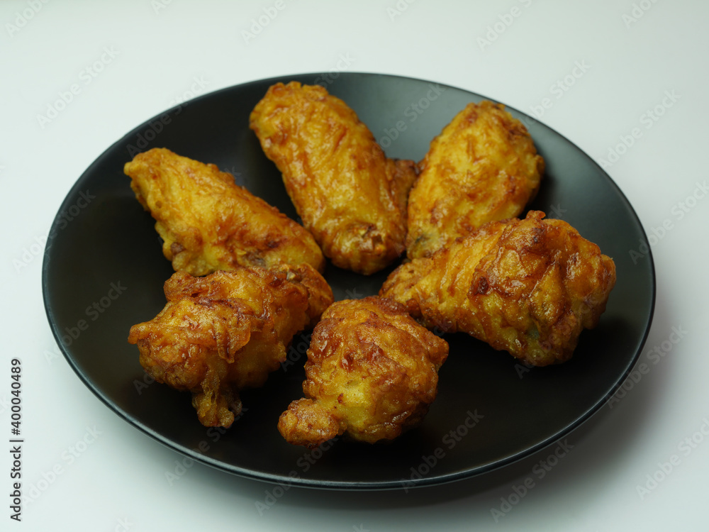 deep crispy fried chicken wings with garlic sauce on black dish, Korean style fried chicken deep crispy fried chicken wings with garlic sauce on black dish, Korean style fried chicken
