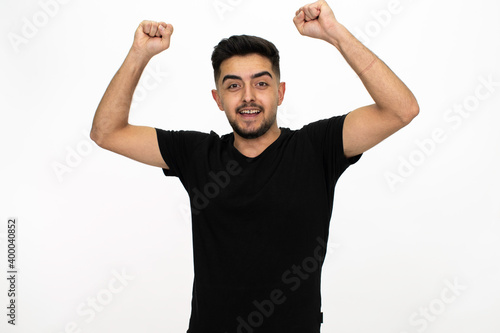 Young male model posing at studio. He is wearing a black shirt. Isolated image and white background.