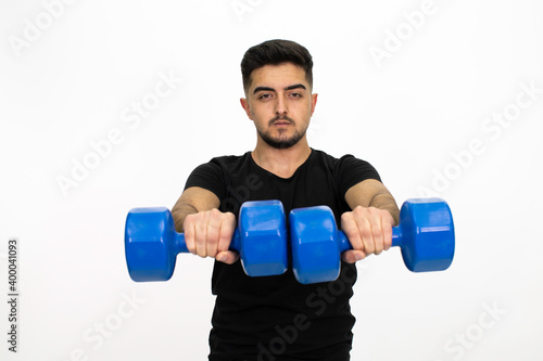 Young male model with dumbbells in his hand.Young man doing fitness. He is wearing a black shirt. Isolated pattern and white background.