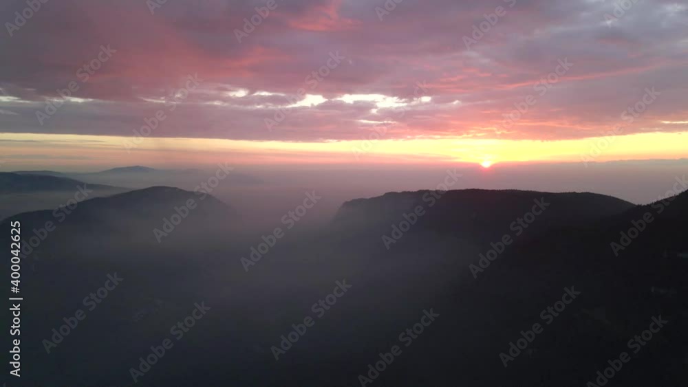 Vibrant Sunrise on Horizon above Swiss Alps Mountaintops in the Clouds Vibrant Sunrise on Horizon above Swiss Alps Mountaintops in the Clouds