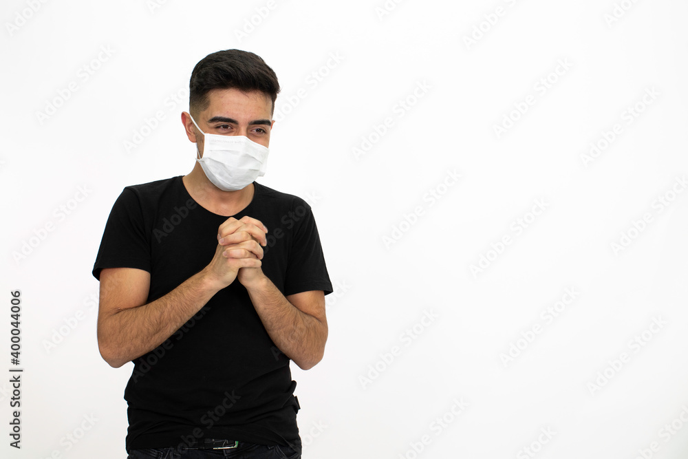 Young male model wearing a medical face mask. He is wearing a black shirt. White background and isolated image. Young male model wearing a medical face mask. He is wearing a black shirt. White background and isolated image.