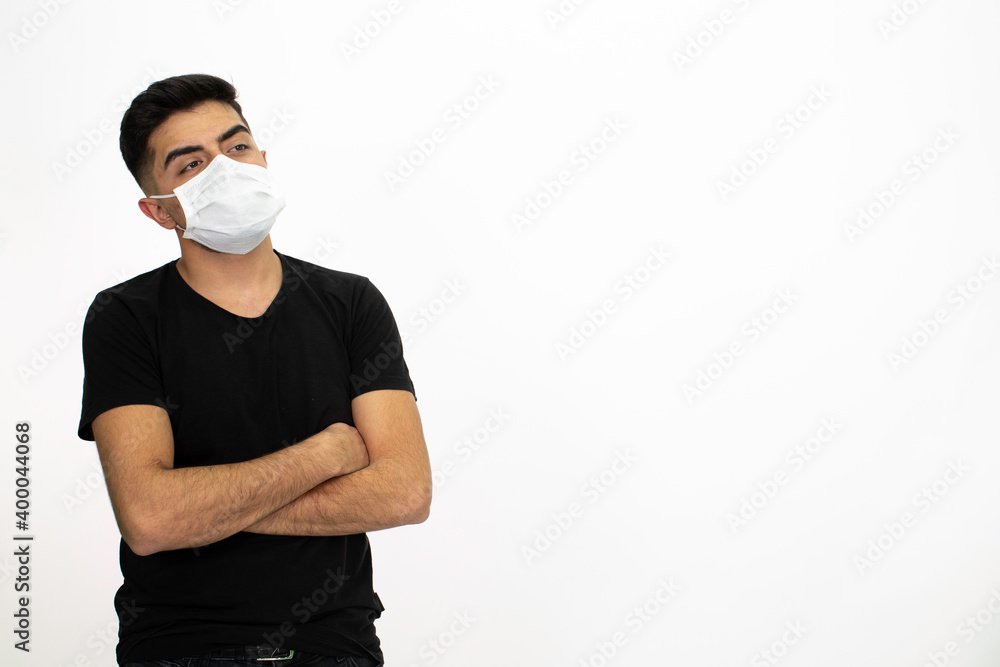Young male model wearing a medical face mask. He is wearing a black shirt. White background and isolated image. Young male model wearing a medical face mask. He is wearing a black shirt. White background and isolated image.