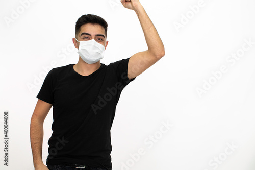 Young male model wearing a medical face mask. He is wearing a black shirt. White background and isolated image.