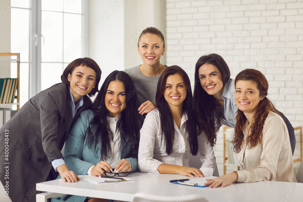 Smiling businesswomen looking at camera during brainstorming in office Smiling businesswomen looking at camera during brainstorming in office
