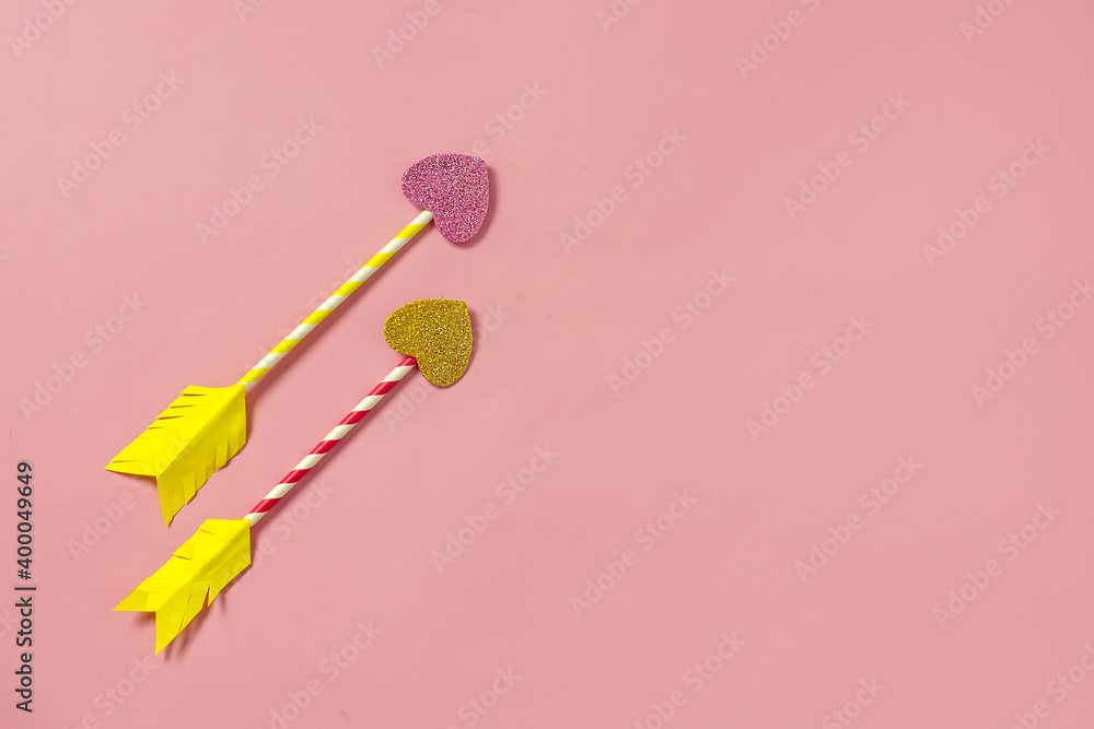 Valentine's day arrow heart background. Homemade arrows from cocktail straws and paper hearts on a pink background, top view, copy space. Creative love background Valentine's day arrow heart background. Homemade arrows from cocktail straws and paper hearts on a pink background, top view, copy space. Creative love background