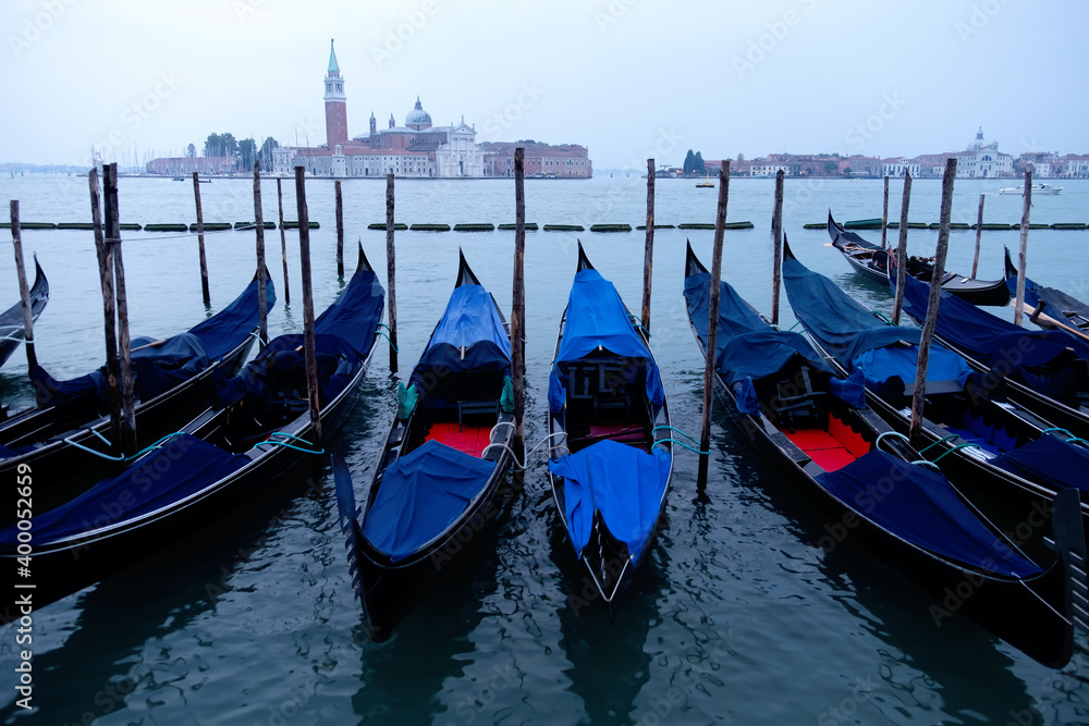 traditional gondolas, tied up to the quay in Saint Mark's square, at the pier in Grand Canal with San Giorgio Maggiore in the background, Venice
