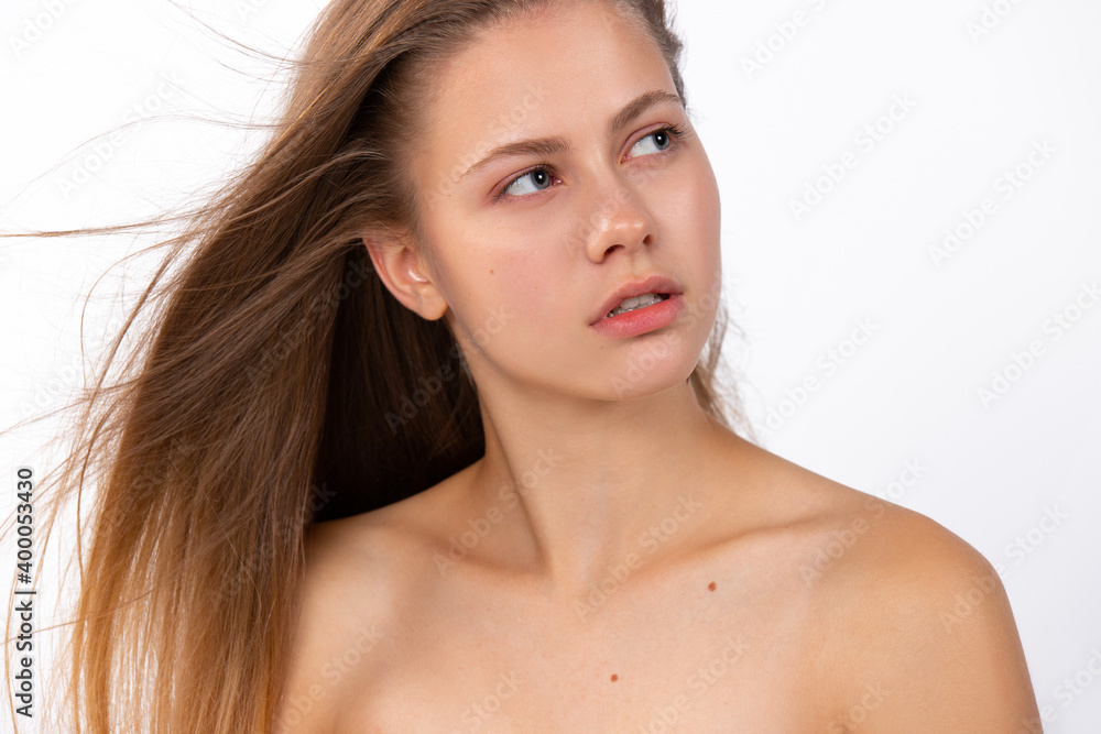Obraz premium Portrait of a blonde, awesome girl, looking to the side . White background. Beauty, spa, hair care and wellness concept.