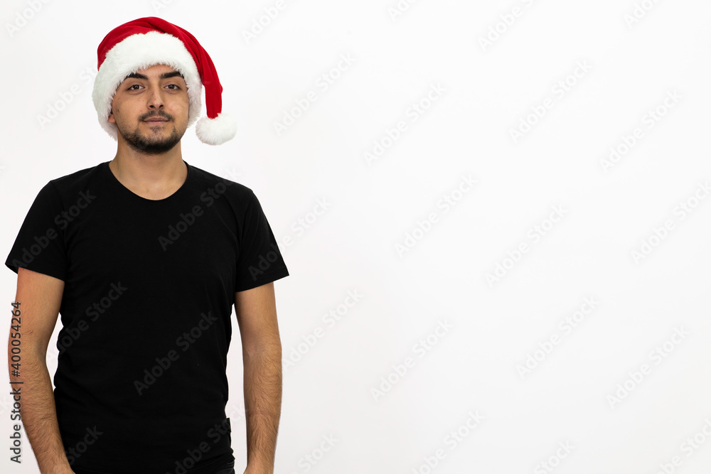Young man wearing a Santa hat. He is wearing a black shirt. Isolated image white background. Young man wearing a Santa hat. He is wearing a black shirt. Isolated image white background.