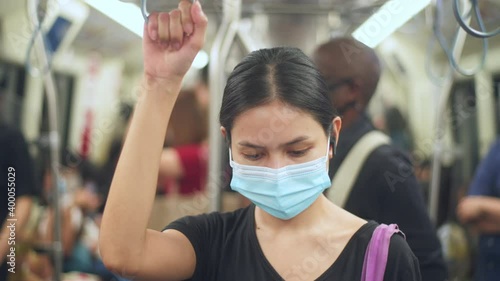 An young woman is wearing protective mask in metro , covid-19 protection , safety travel , new normal , social distancing , safety transportation , travel under pandemic concept . photo